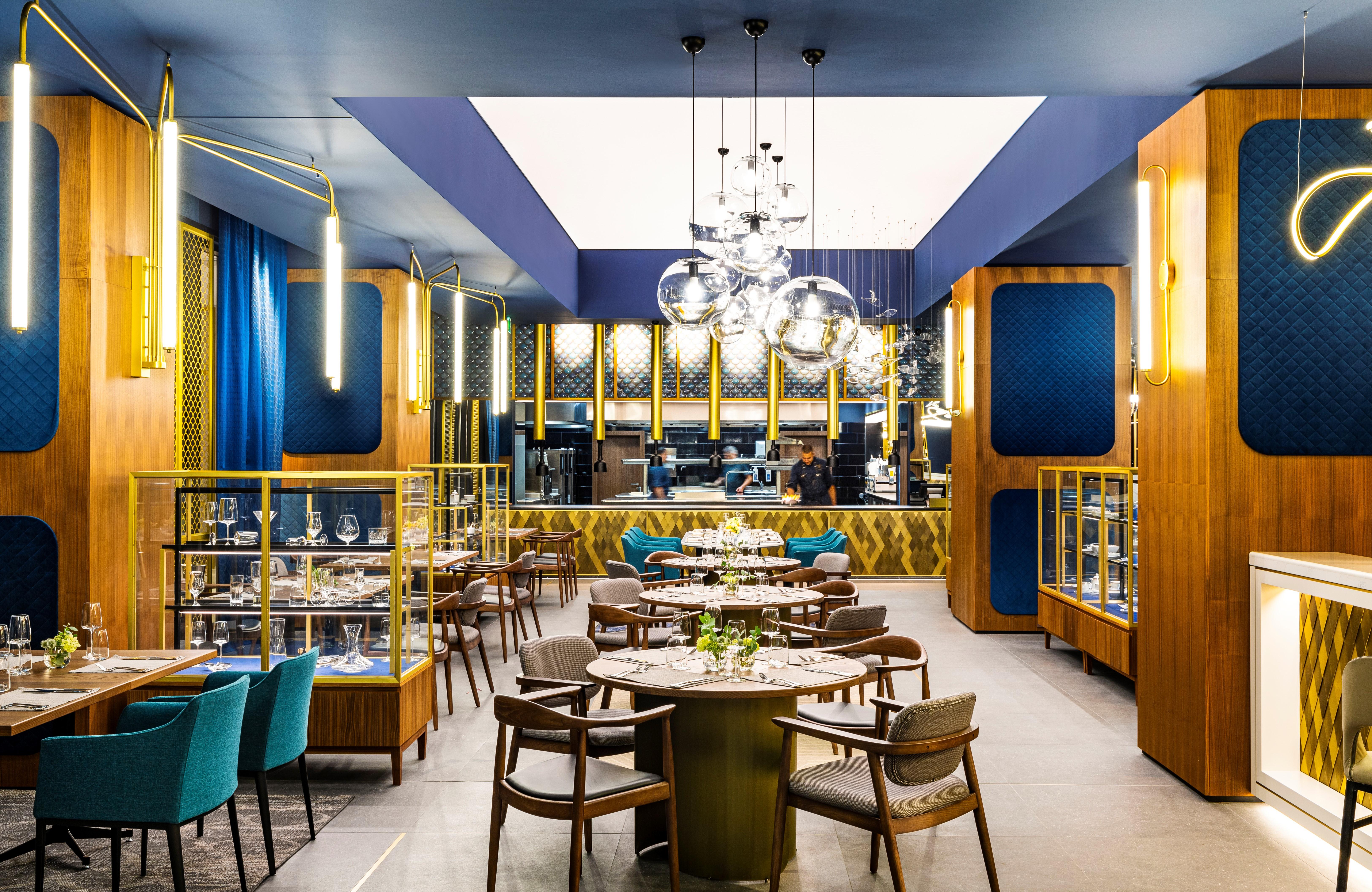 Grand Hotel Millennium Софія Екстер'єр фото The photo depicts a modern restaurant interior characterized by sleek and elegant design elements. The space features wooden accents, with warm tones creating an inviting atmosphere. 

Tables are arranged centrally, surrounded by comfortable upholste