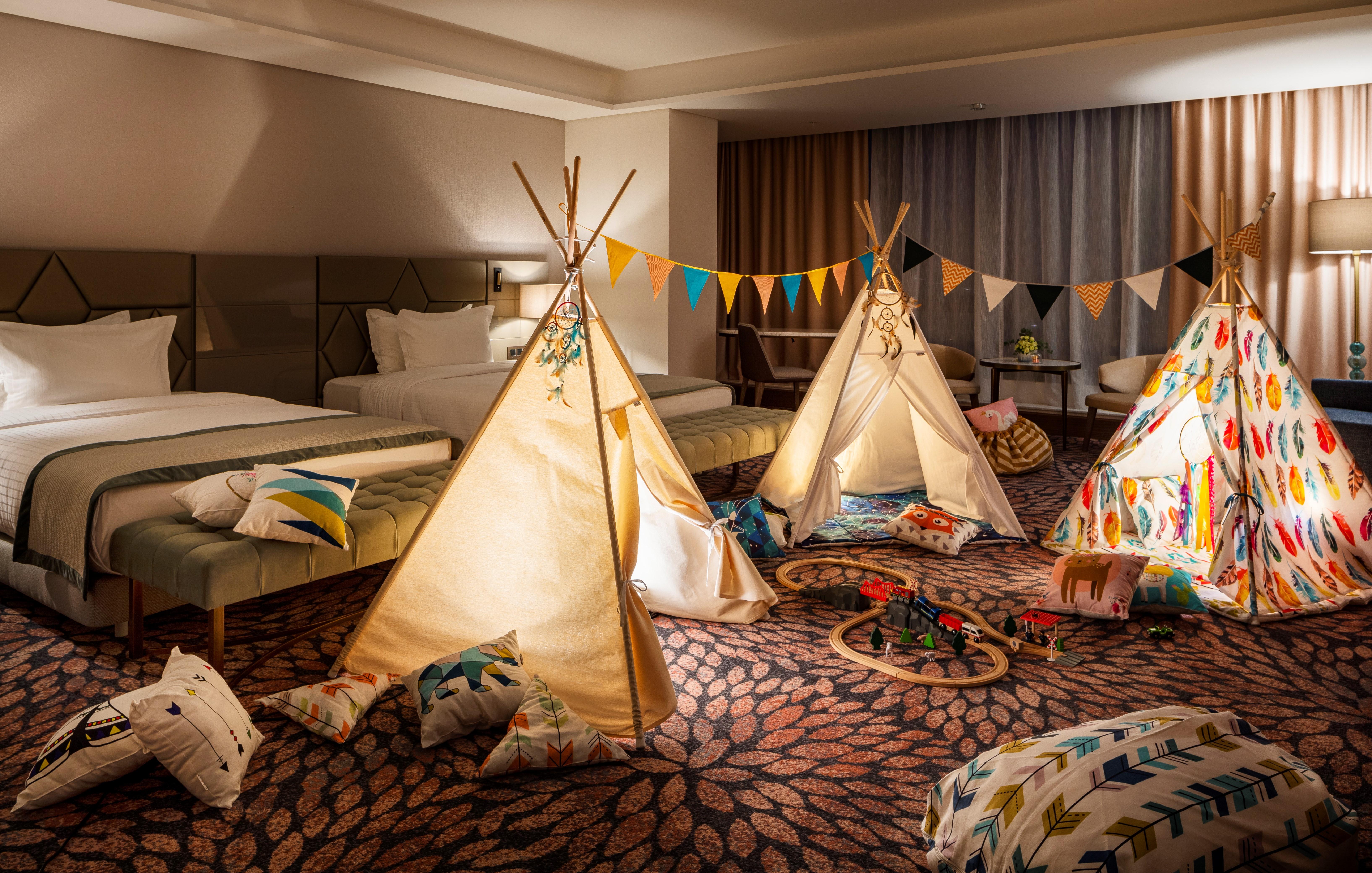 Grand Hotel Millennium Софія Екстер'єр фото The photo shows a cozy room featuring three children's teepees made of fabric, arranged in a playful manner. The teepees are decorated with colorful patterns and surrounded by various cushions and pillows scattered on the floor. There are also decora